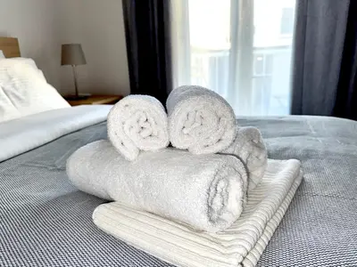 a pile of towels sitting on top of a bed at Piraeus 2 bedrooms apartment in Piraeus