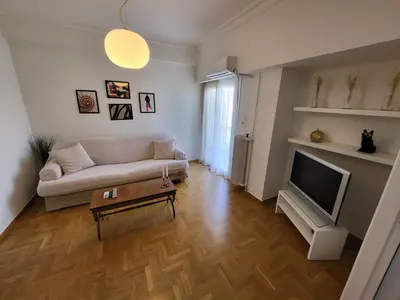 a living room with a couch and a tv at Central View Apartment in Athens