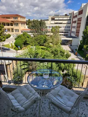 a balcony with a glass table and two chairs at Central View Apartment in Athens