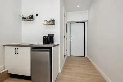 a kitchen with white cabinets and a counter and a door at Exquisite Athens Center Suite in Athens