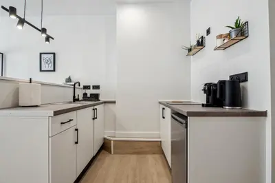 a kitchen with white cabinets and a counter top at Exquisite Athens Center Suite in Athens