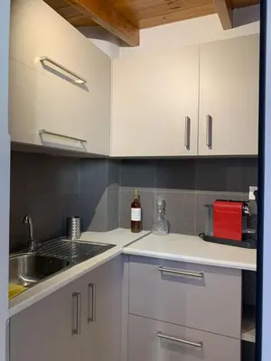 a kitchen with white cabinets and a sink at Athens Central Hideout next to Acropolis in Athens