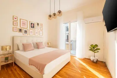 a white bedroom with a bed and a window at Emilia Athens in Athens