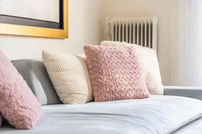 a couch with pink and white pillows on it at Emilia Athens in Athens