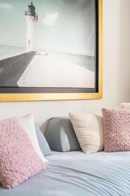 a bed with pillows and a picture of a lighthouse at Emilia Athens in Athens