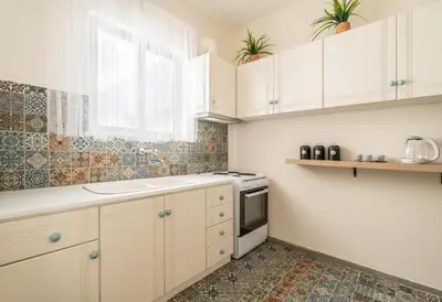 a kitchen with white cabinets and a sink and a window at Emilia Athens in Athens