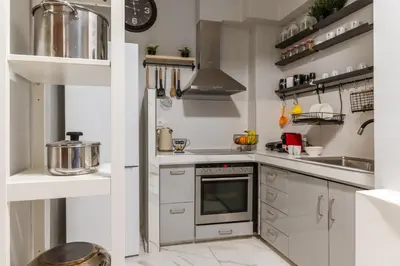 a kitchen with white cabinets and a stove at Athens Central Stay, 3BD Apartment, 3min Metro in Athens