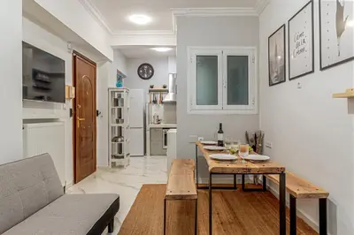 a living room with a table and a kitchen at Athens Central Stay, 3BD Apartment, 3min Metro in Athens