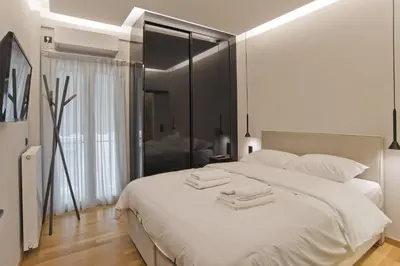 a bedroom with a white bed with two towels on it at Stylish Ilisia Stay Luxury Fully Reno 2BR, 2BA Apt in Athens