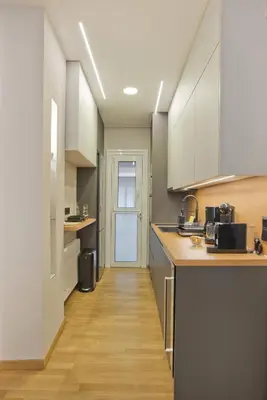 a kitchen with white cabinets and a wooden floor at Stylish Ilisia Stay Luxury Fully Reno 2BR, 2BA Apt in Athens