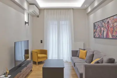 a living room with a couch and a tv at Stylish Ilisia Stay Luxury Fully Reno 2BR, 2BA Apt in Athens