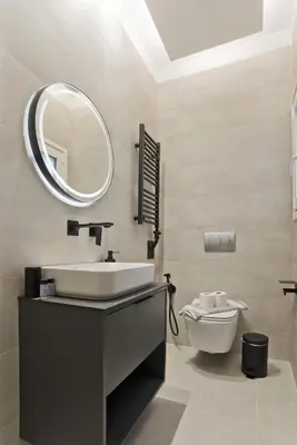 a bathroom with a sink and a mirror and a toilet at Stylish Ilisia Stay Luxury Fully Reno 2BR, 2BA Apt in Athens