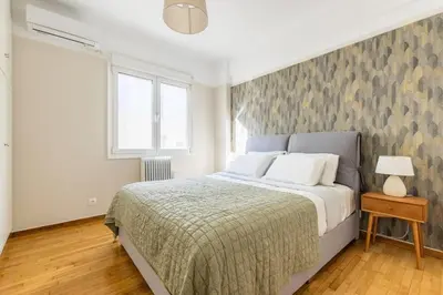 a bedroom with a large bed and a window at Modern Home W Balcony Near Kolonaki in Athens
