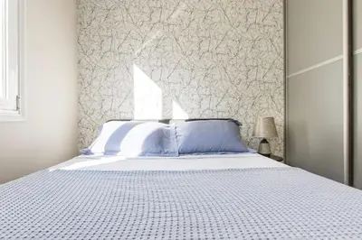 a bedroom with a white bed and a wall at Modern Home W Balcony Near Kolonaki in Athens