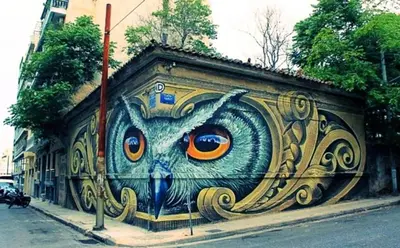 a mural of an owl with orange eyes on a wall at Modern Home W Balcony Near Kolonaki in Athens