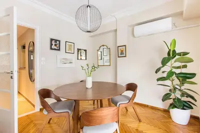 a dining room with a table and chairs and a potted plant at Modern Home W Balcony Near Kolonaki in Athens