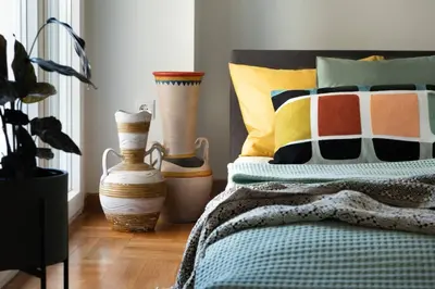 a bedroom with a bed with colorful pillows and vases at Almost A Penthouse But Better W Acropolis Glimpse in Athens