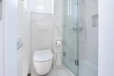 a white bathroom with a toilet and a glass shower at Almost A Penthouse But Better W Acropolis Glimpse in Athens