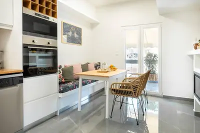 a kitchen with a table and chairs in a room at Almost A Penthouse But Better W Acropolis Glimpse in Athens