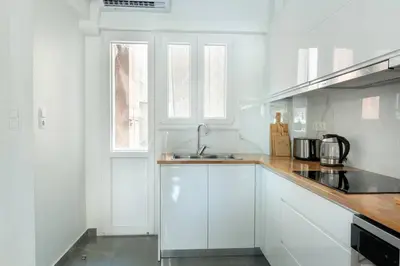 a white kitchen with white cabinets and a sink at Almost A Penthouse But Better W Acropolis Glimpse in Athens