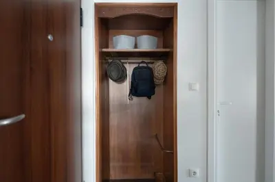 a closet with a wooden door with a backpack on it at Almost A Penthouse But Better W Acropolis Glimpse in Athens