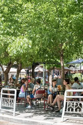 a group of people sitting in chairs under a tree at Almost A Penthouse But Better W Acropolis Glimpse in Athens