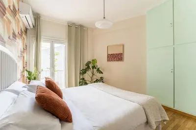 a bedroom with a white bed and a window at Quiet 1br Home Near Plaka & Acropolis in Athens