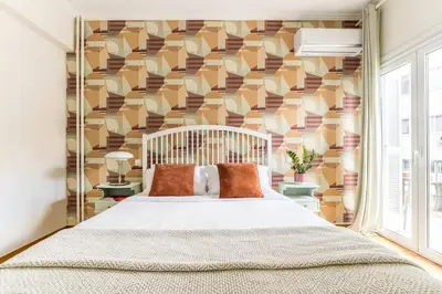 a bedroom with a large bed and a geometric wall at Quiet 1br Home Near Plaka & Acropolis in Athens