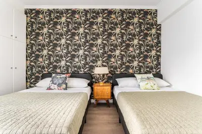 two beds in a room with a wallpaper with palm trees at Spacious 3br Home Near Acropolis Museum in Athens