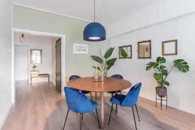 a dining room with a wooden table and blue chairs at Spacious 3br Home Near Acropolis Museum in Athens