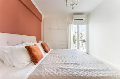 a bedroom with a large white bed with orange walls at Spacious 3br Home Near Acropolis Museum in Athens