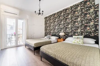 a bedroom with two beds and a wall mural at Spacious 3br Home Near Acropolis Museum in Athens