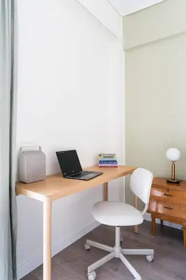 a wooden desk with a laptop and a chair at Spacious 3br Home Near Acropolis Museum in Athens