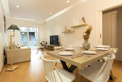 a dining room with a table and white chairs at Cozy apartment in Koukaki in Athens