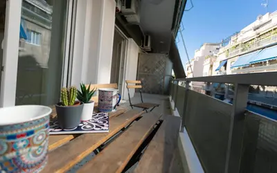 a balcony with a wooden table with plants on it at Cozy apartment in Koukaki in Athens