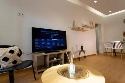 a living room with a flat screen tv and a table at Cozy apartment in Koukaki in Athens
