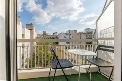 a balcony with a table and two chairs and a window at Acropolis Vista Retreat in Athens
