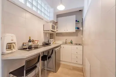 a small kitchen with white cabinets and a counter at Acropolis Vista Retreat in Athens