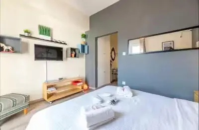 a bedroom with a large white bed and a mirror at Acropolis Vista Retreat in Athens