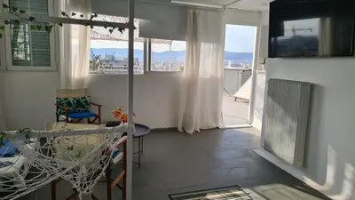 a living room with a table and chairs and a balcony at Athens city view loft on a budget in Athens