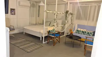 a bedroom with a swinging bed and a table and chairs at Athens city view loft on a budget in Athens