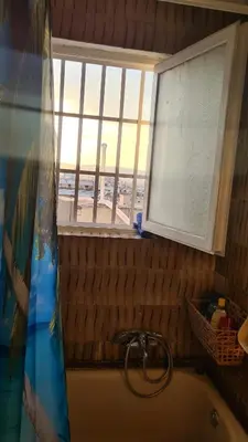 a bathroom with a tub and a window with a view of the beach at Athens city view loft on a budget in Athens