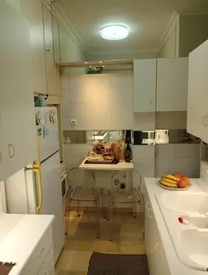 a small kitchen with white cabinets and a sink at Kolonaki Art Suite in Athens