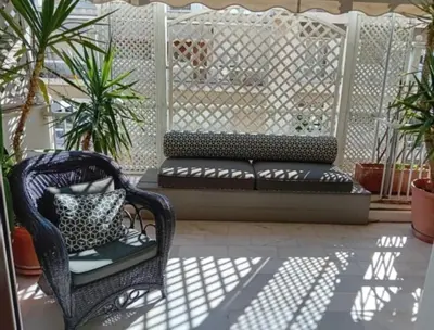 a porch with a bench and a chair and plants at Kolonaki Art Suite in Athens