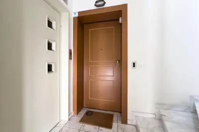 a brown door in a hallway with a tile floor at Spacious Family Apt in Glyfada in Athens