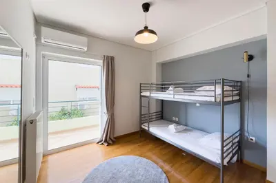 a bedroom with two bunk beds and a window at Spacious Family Apt in Glyfada in Athens