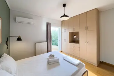 a bedroom with a large white bed and a window at Spacious Family Apt in Glyfada in Athens