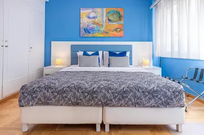 a bedroom with a large bed with blue walls at Phaedrus Living Kolonaki Blue in Athens