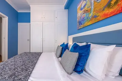 a bedroom with blue walls and a bed with pillows at Phaedrus Living Kolonaki Blue in Athens