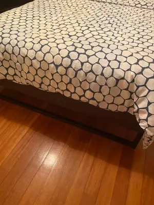 a bed with a white comforter on top of a wooden floor at Spyros apartment 2 in Athens